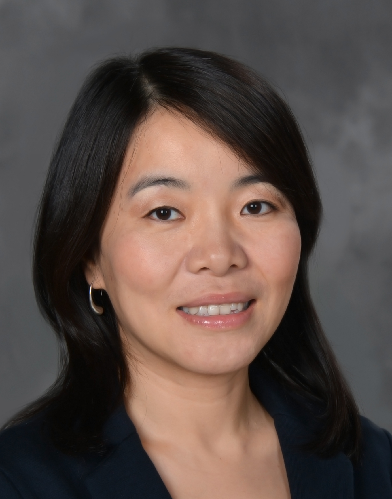 Headshot of Wenhua Di from the shoulders up smiling and wearing a blazer.